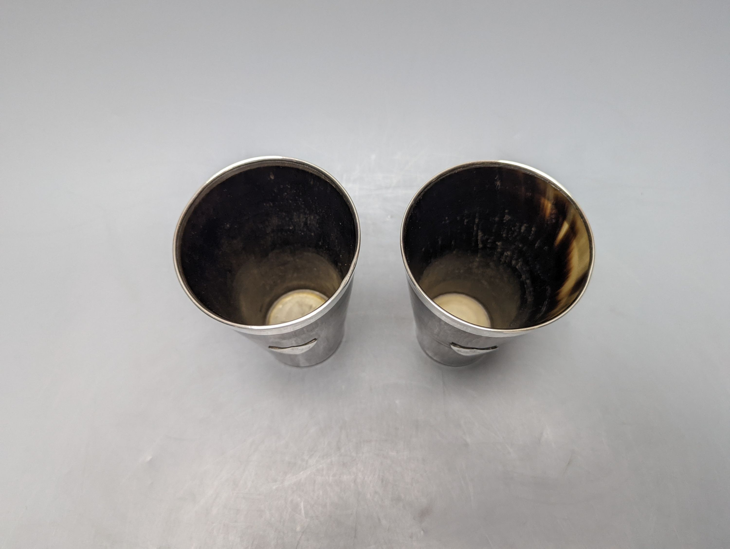 A pair of late Victorian silver mounted horn beakers, with crested shield appliques, John Newton Mappin, London, 1882, 14.1cm.